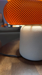 Lamp with orange textured shade on a wooden surface